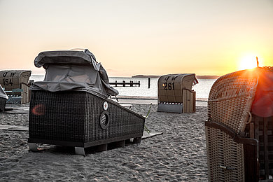 Schlafstrandkörbe von hinten am Strand, Blick aufs Meer,