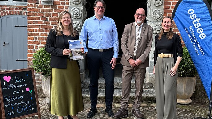 Das Bild zeigt folgende Personen Katja Lauritzen, Geschäftsführerin OHT, Egon Perschk, Bürgermeister der Stadt Glücksburg und neues Vorstandsmitglied, Jörg Weber, Vorstandsvorsitzender und Julia Bünting, stellvertretende Geschäftsführerin OHT. 